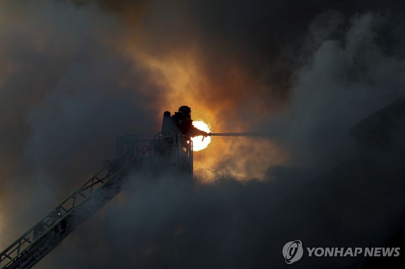 러시아 드론 공격으로 화재가 발생한 자포리자에서 소방대원이 진화 작업에 나서고 있다 / 연합뉴스