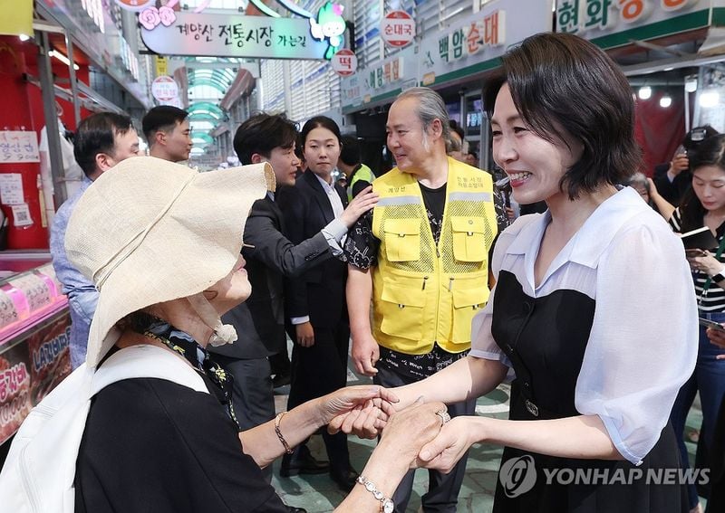 김혜경 여사가 25일 인천 계양산전통시장을 방문해 한 시민과 인사하고 있다. 2025.7.25 [대통령실통신사진기자단]
